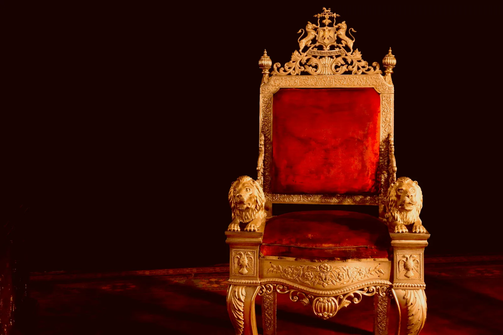 Ornate golden throne with red velvet and lion armrests