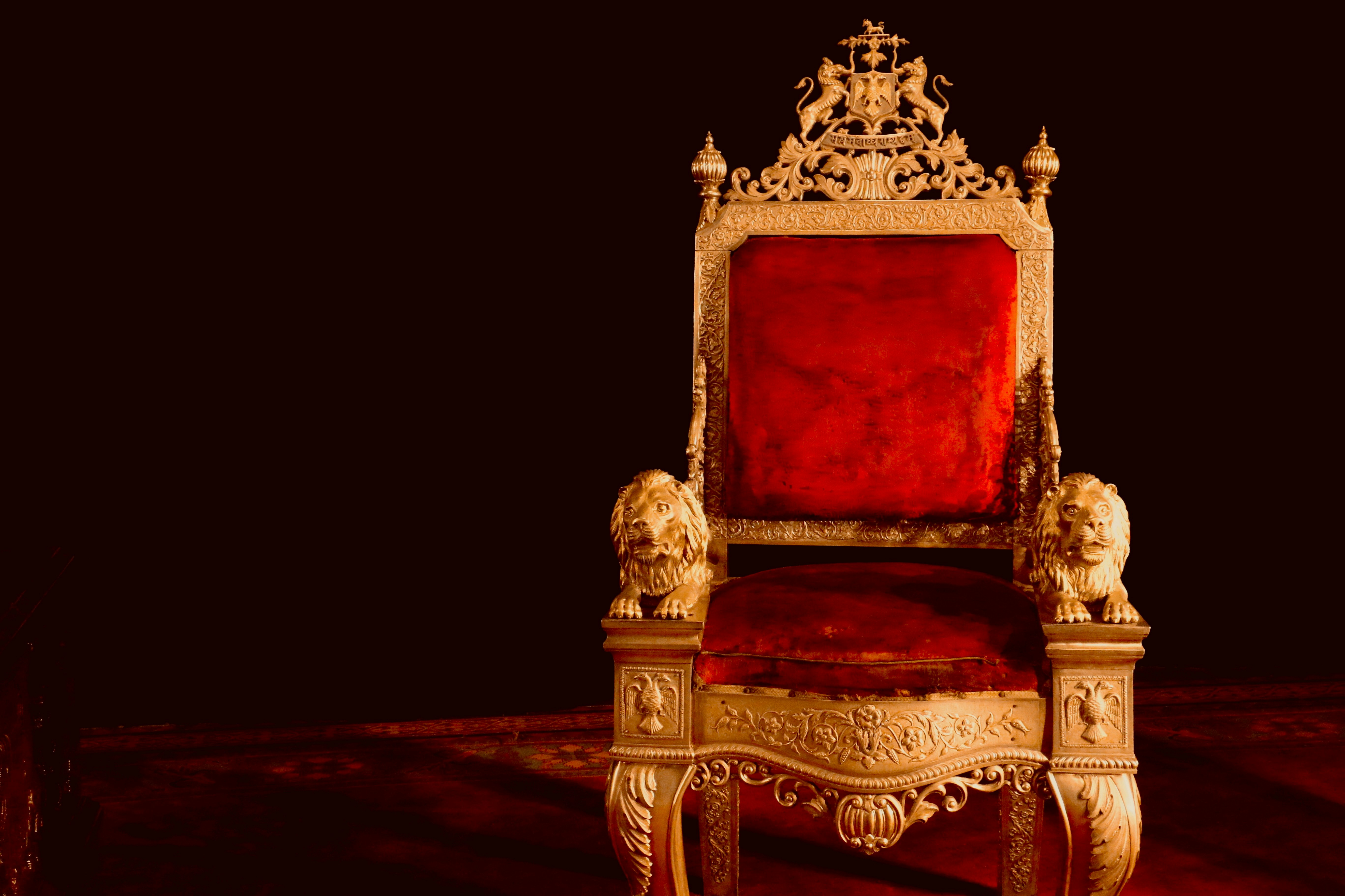 Ornate golden throne with red velvet and lion armrests